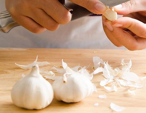 What Happens If You Drink Garlic Tea?- peeling garlic