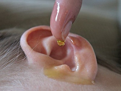 Homemade Garlic Ear Drops - pouring oil in ear
