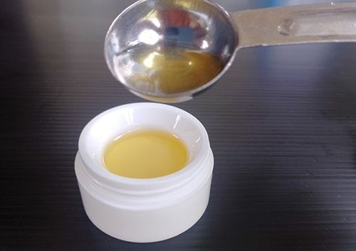 Homemade Psoriasis and Eczema Salve -spoon the oil into a jar