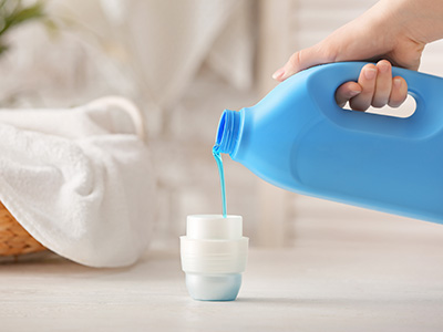 Woman with laundry detergent at home