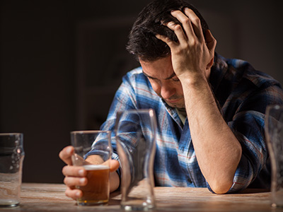 alcoholism, alcohol addiction and people concept - male alcoholic drinking beer from glass at night