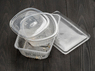 Dirty plastic food container on dark wooden background