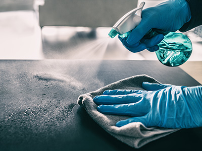 Surface sanitizing against COVID-19 outbreak. Home cleaning spraying antibacterial spray bottle disinfecting against coronavirus wearing nitrile gloves. Sanitize hospital surfaces prevention.