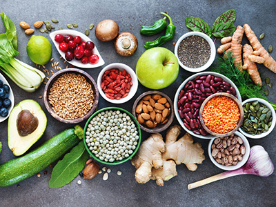 Healthy food selection with fruits, vegetables, seeds, superfood, cereals on gray background