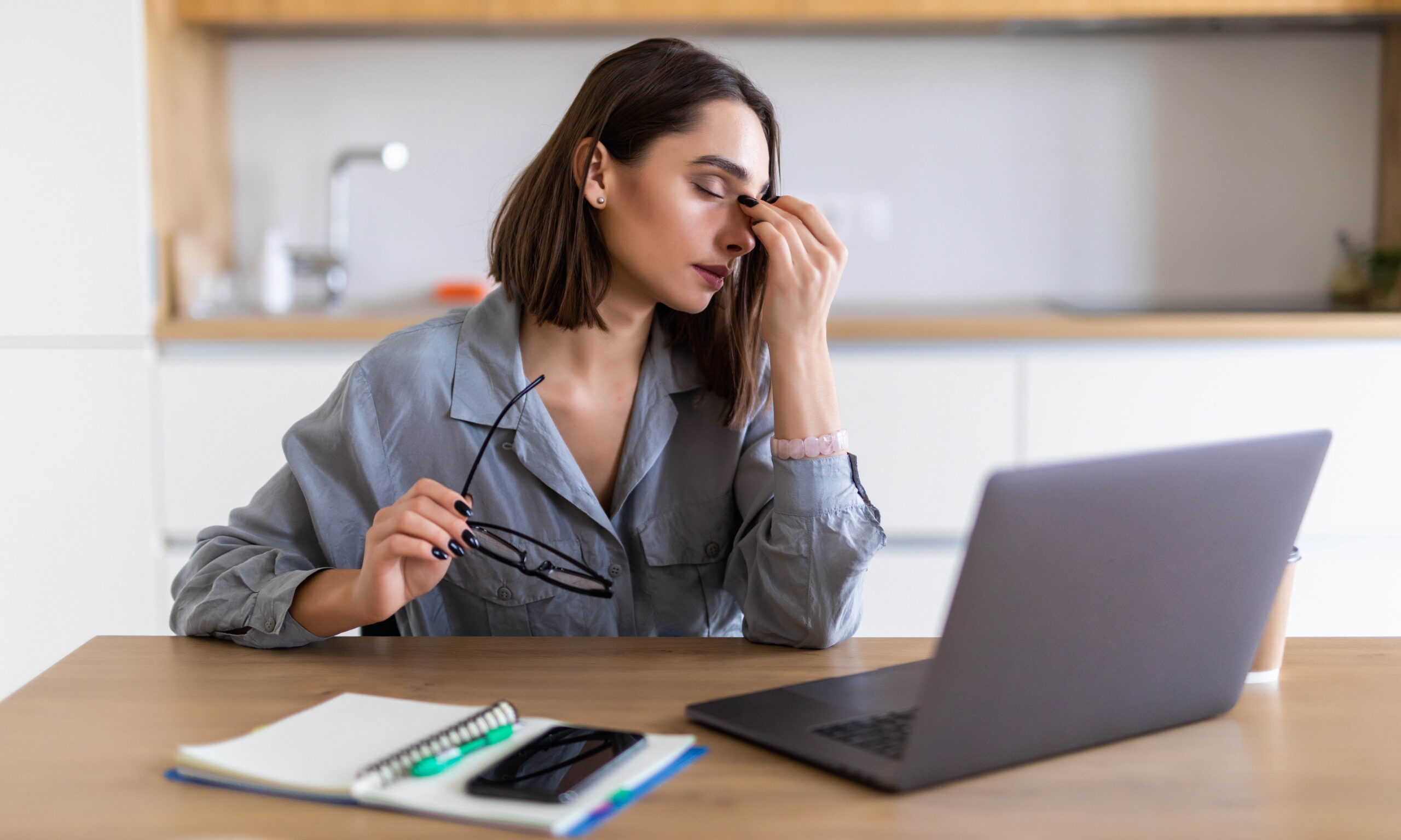Upset woman working from home office. Unhappy freelancer using laptop and the Internet. Workplace in cozy kitchen. Concept of female business and career, housekeeping, stress. Lifestyle moment.