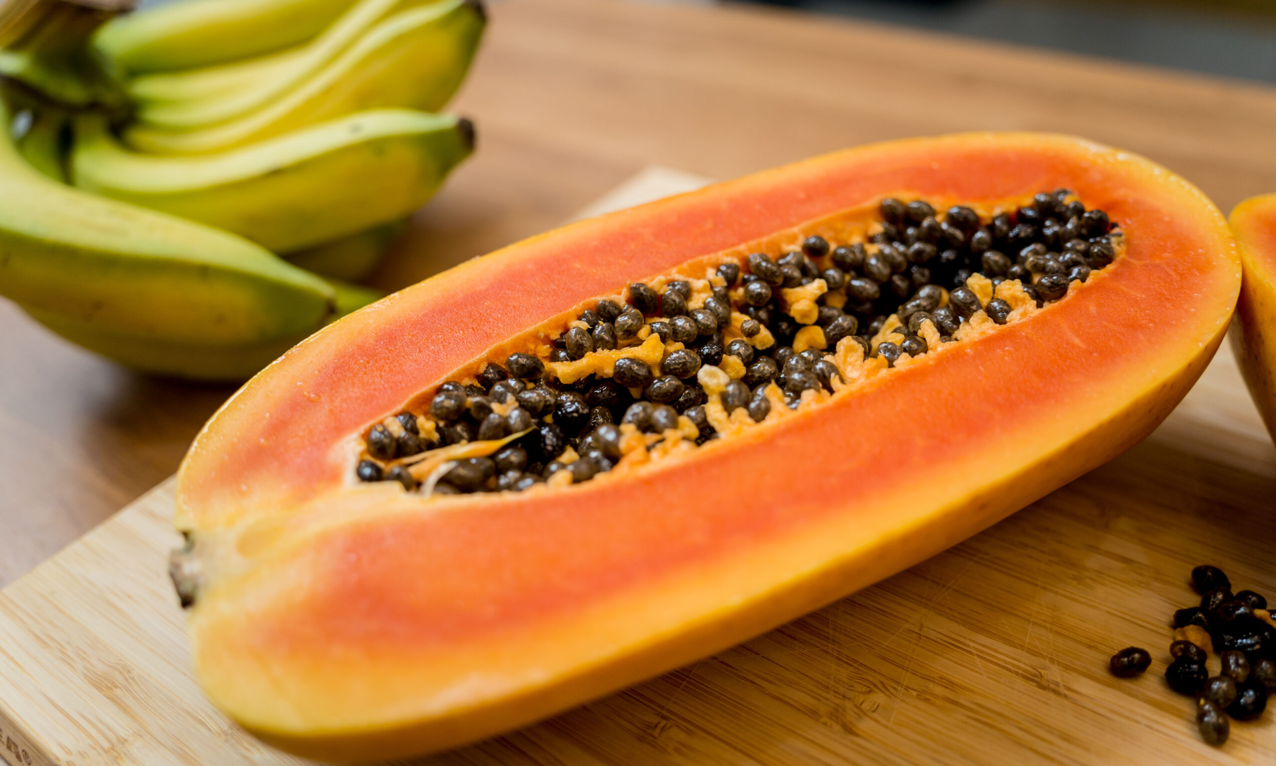 Chef cuts and peels papaya on the cutting board.