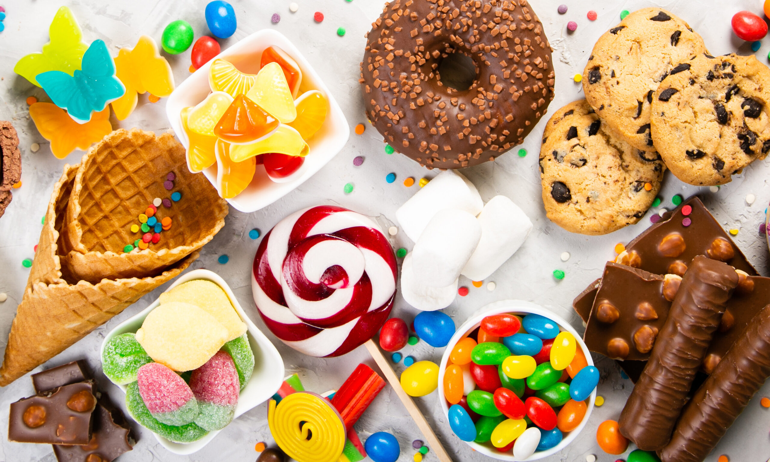 Selection of colorful sweets - chocolate, donuts, cookies, lollipops, ice cream top view
