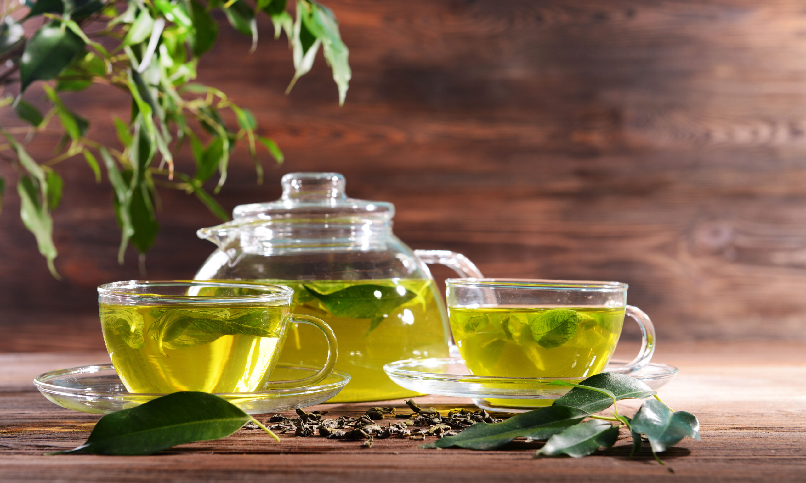 Cups of green tea on table on wooden background