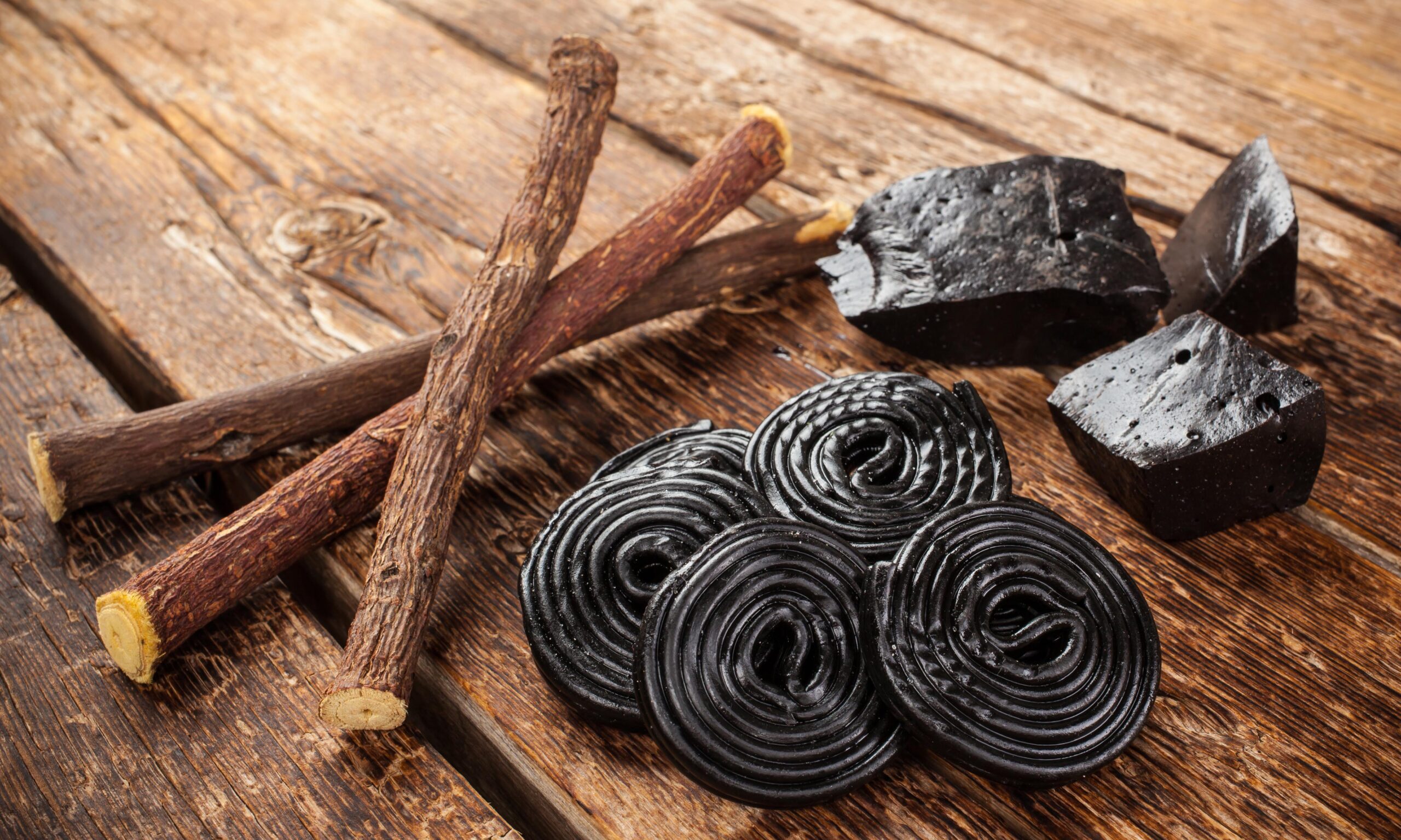 Production steps of licorice, roots, pure blocks and candy on wooden tableProduction steps of licorice, roots, pure blocks and candy on wooden table