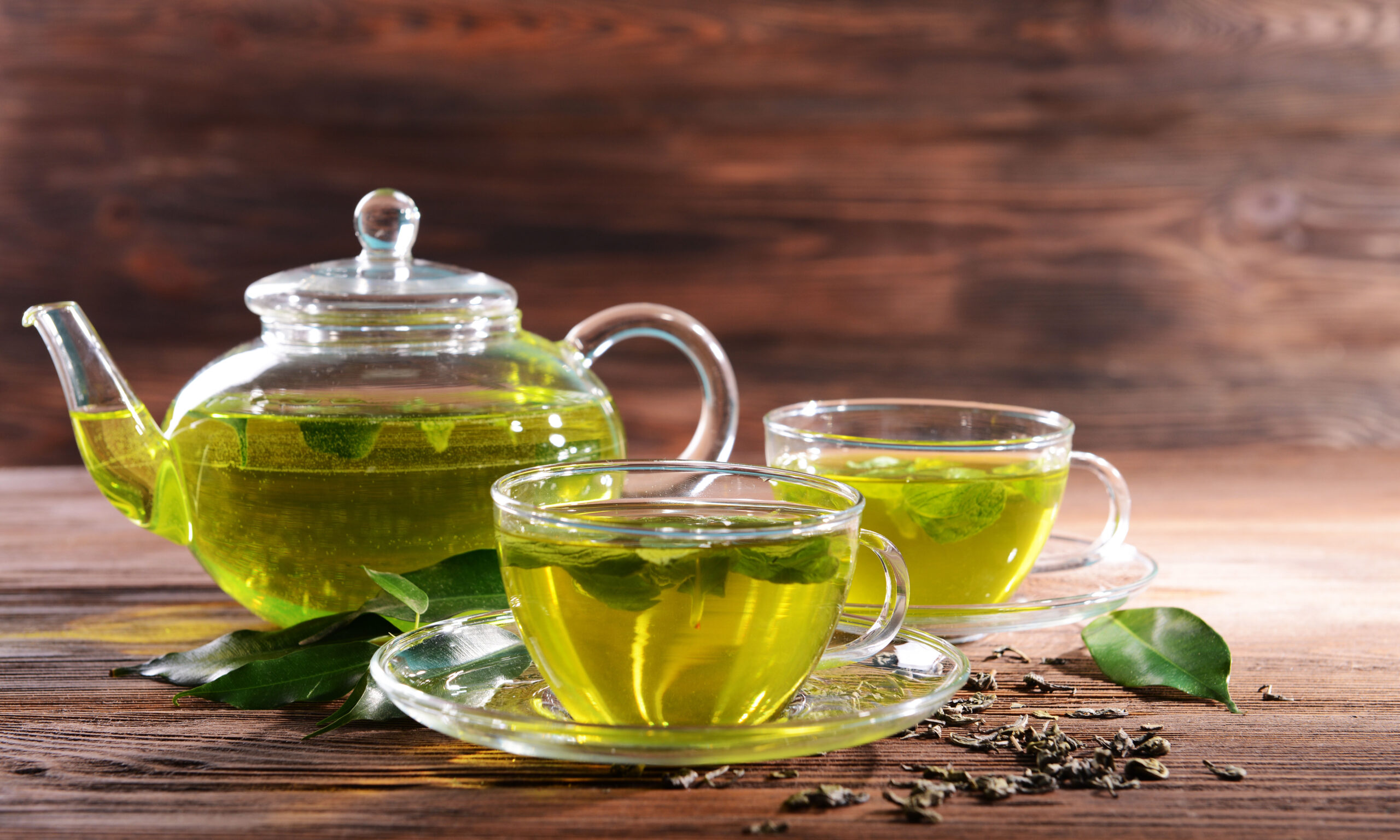 Cups of green tea on table on wooden background
