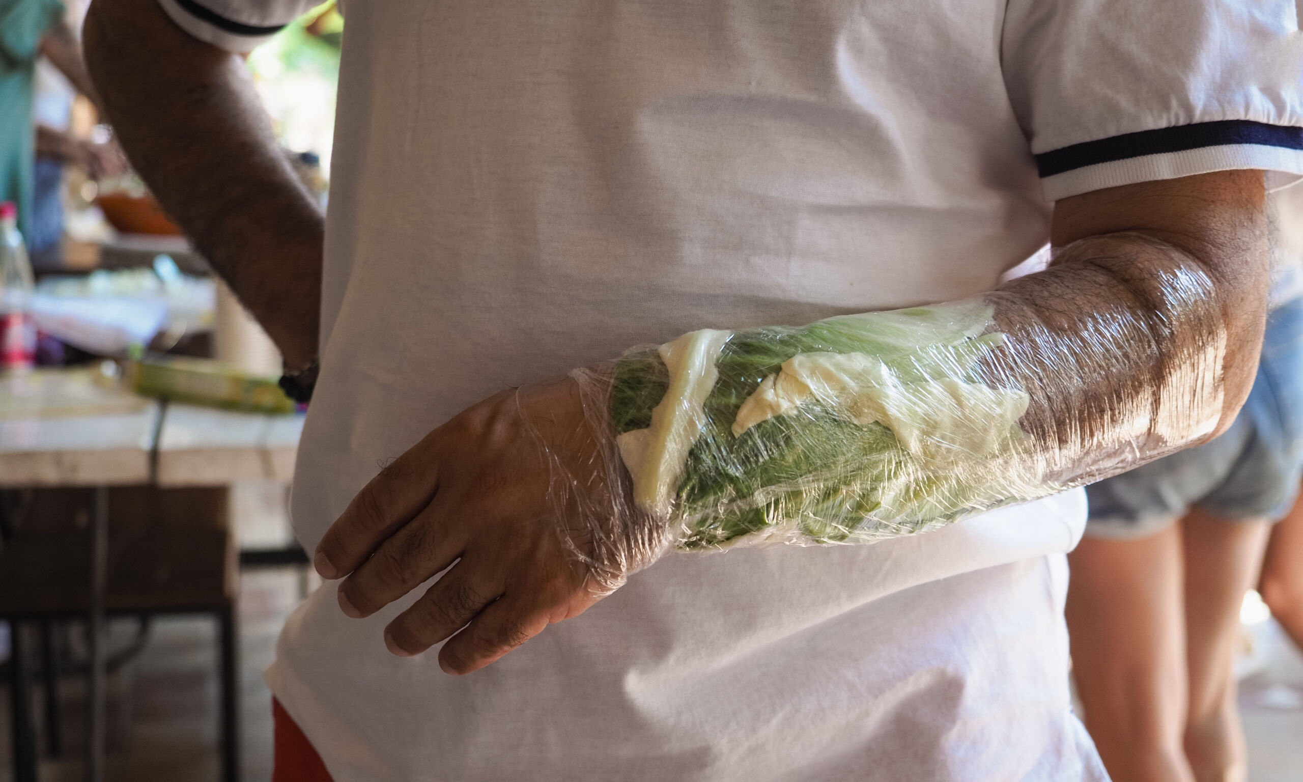 woman wrist wrapped in cabbage leaves compress for anti inflammatory effect. Lower body part inflammation. Natural home made italian antique remedies concept.