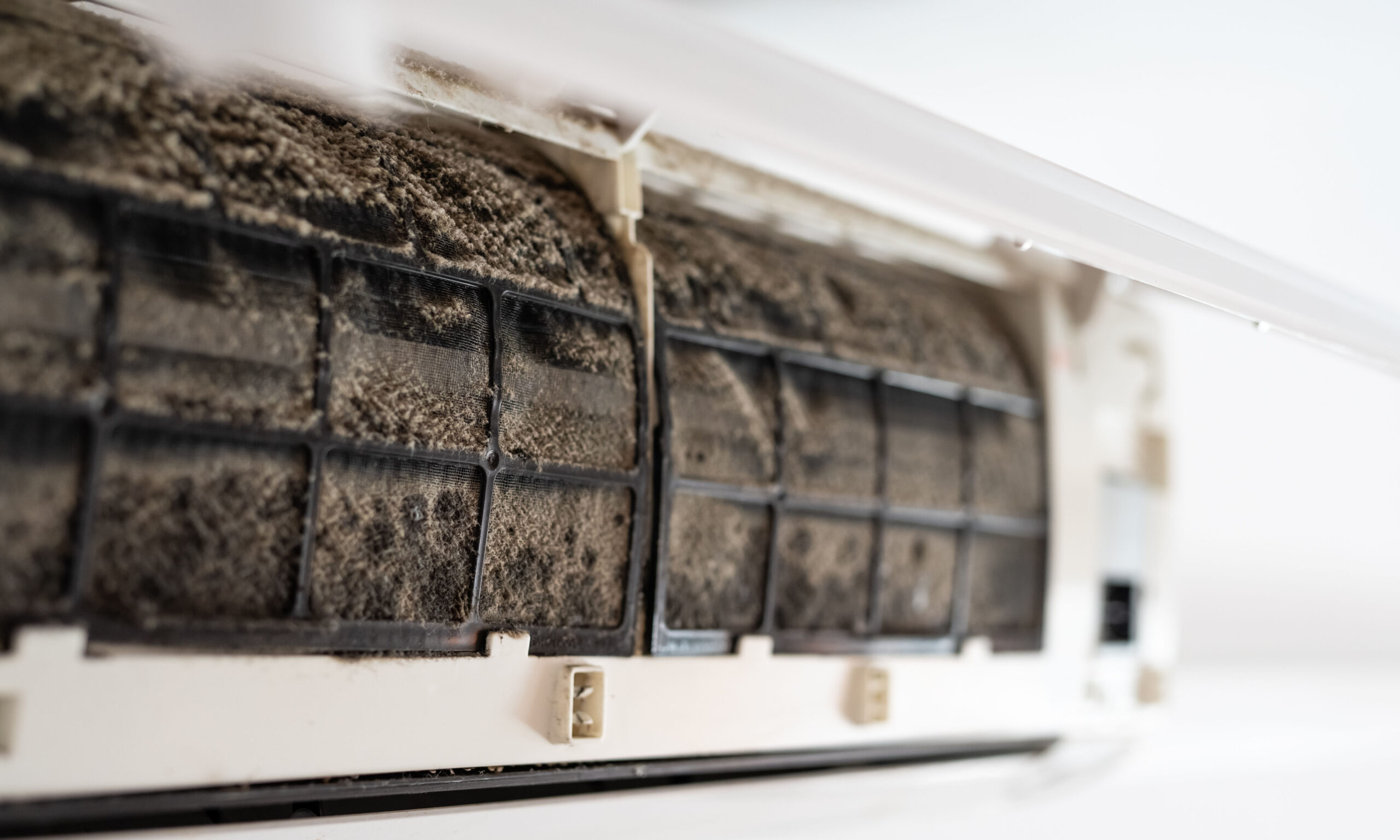 Dirty in dust and mold air conditioner filter close-up. Home air conditioner maintenance.