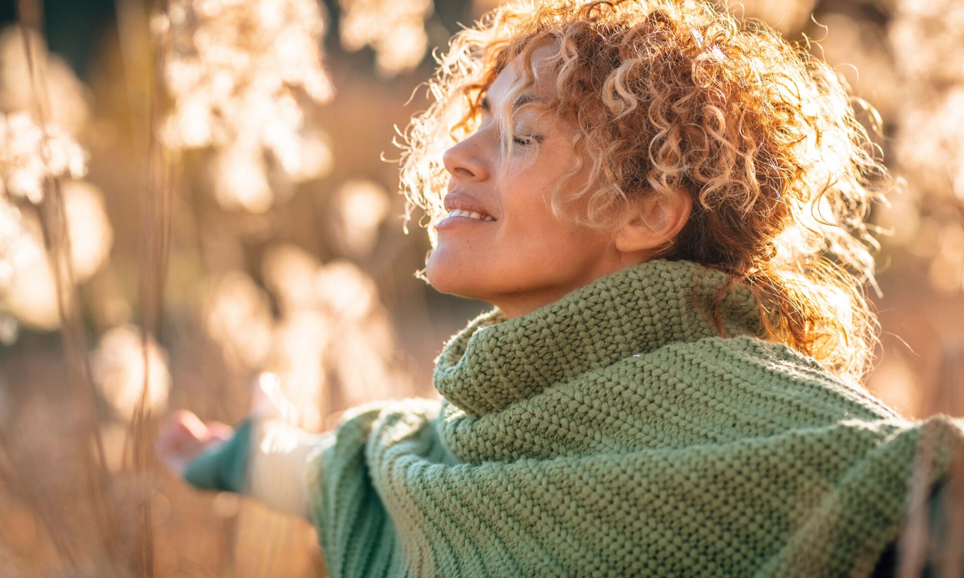 One beauty woman with happy and idyllic expression on face opening arm and enjoying sunset light in the field in scenic outdoor leisure activity. People loving life and healthy lifestyle concept. Life