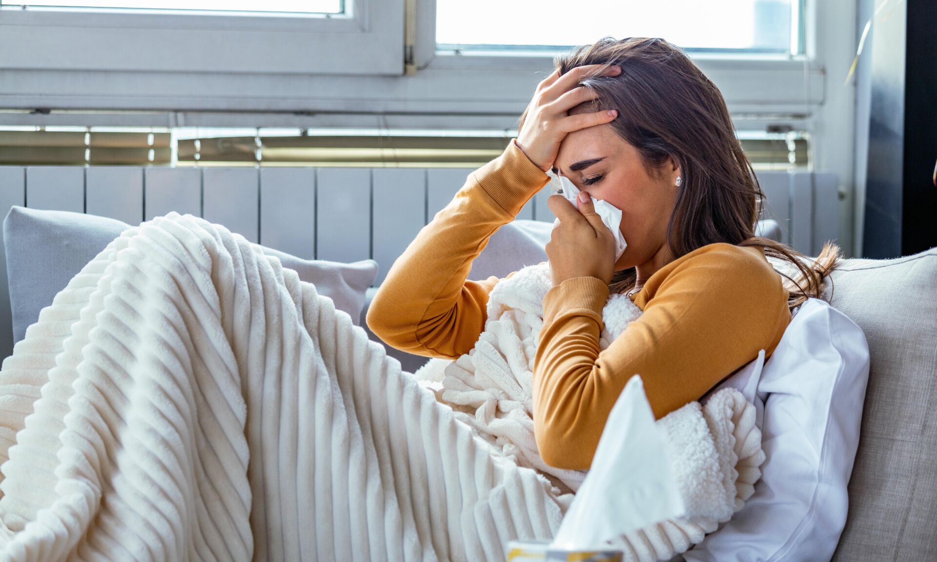 Cold And Flu. Portrait Of Ill Woman Caught Cold, Feeling Sick And Sneezing In Paper Wipe. Closeup Of Beautiful Unhealthy Girl Covered In Blanket Wiping Nose. Healthcare Concept.