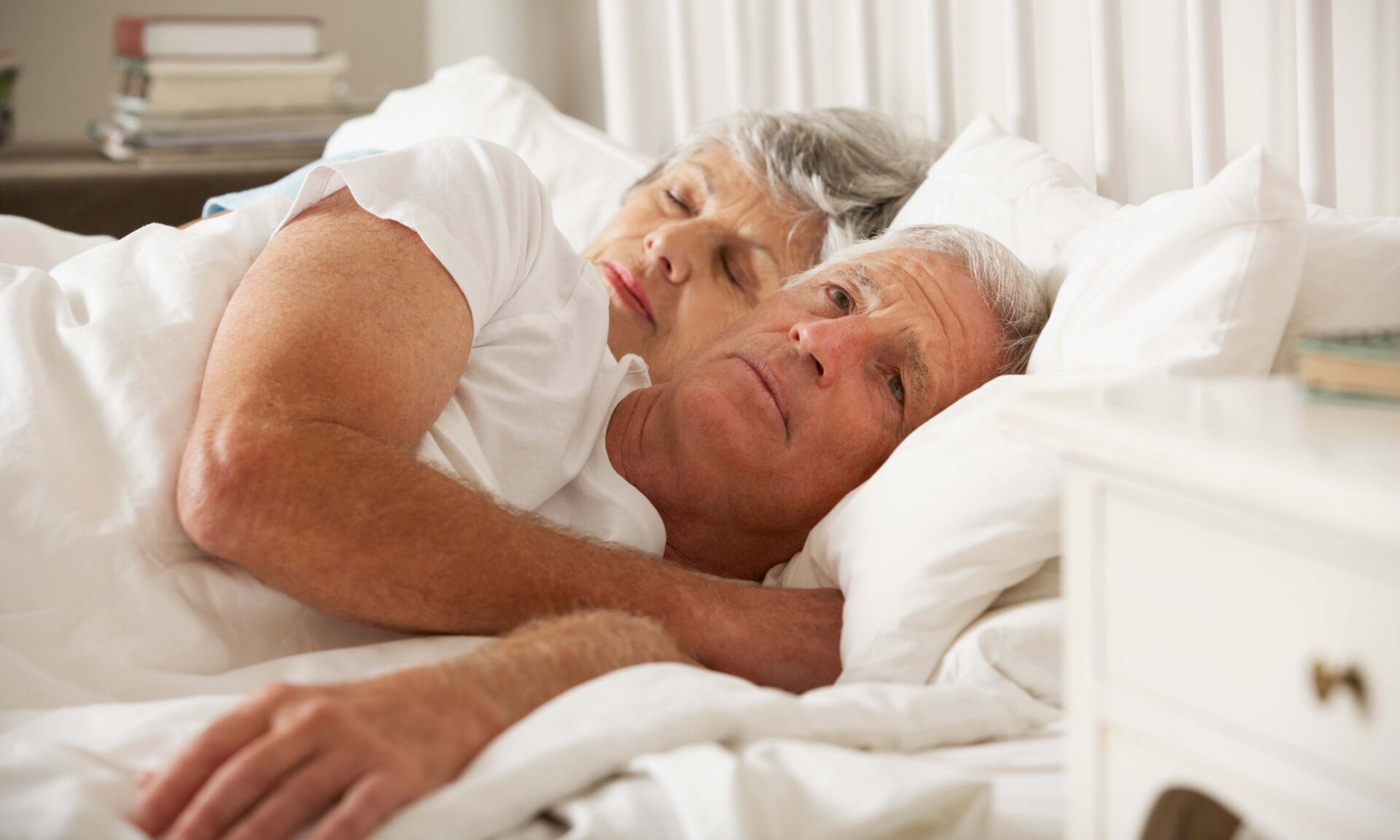Senior Woman Tries To Be Affectionate Towards Husband In Bed