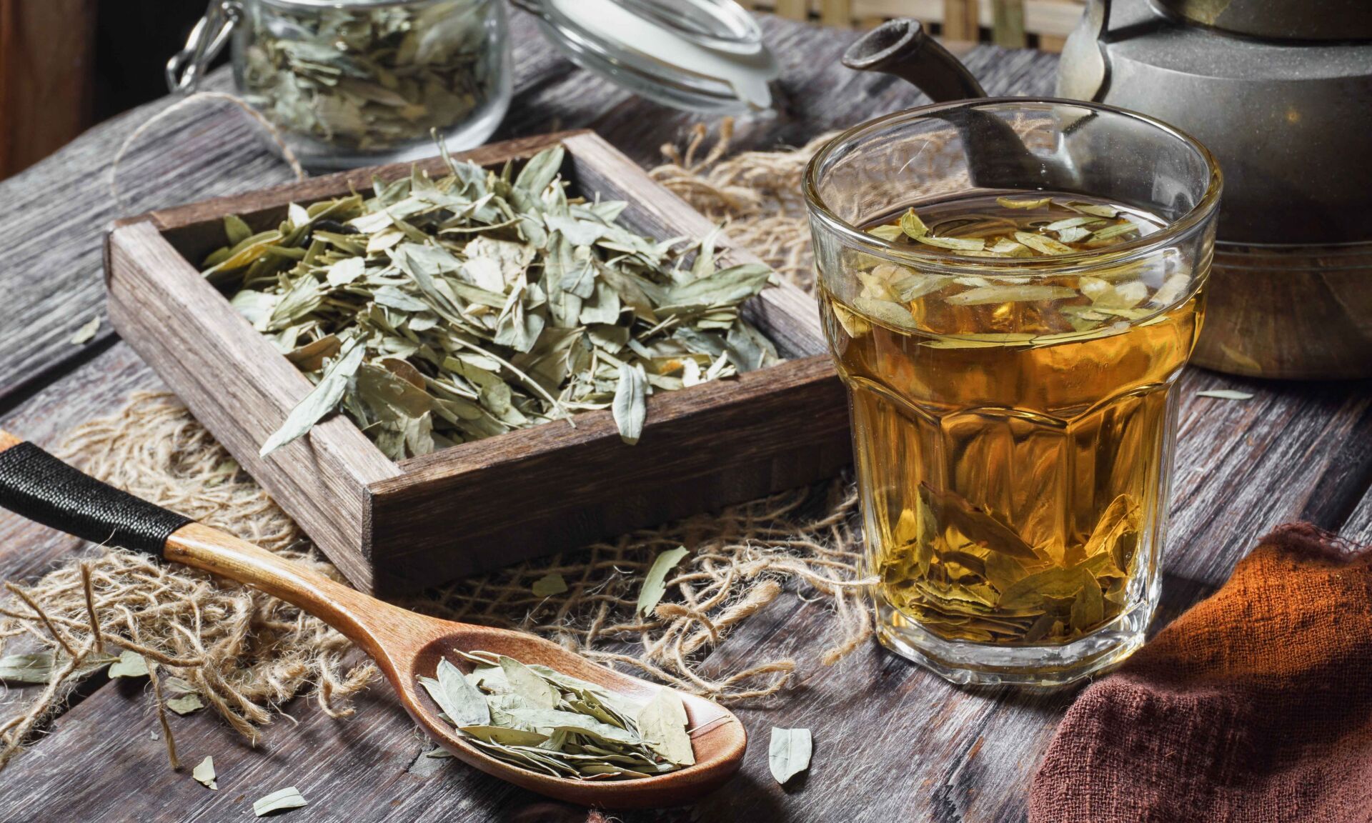 Dried senna in a bowl with a cup of tea on a wooden table