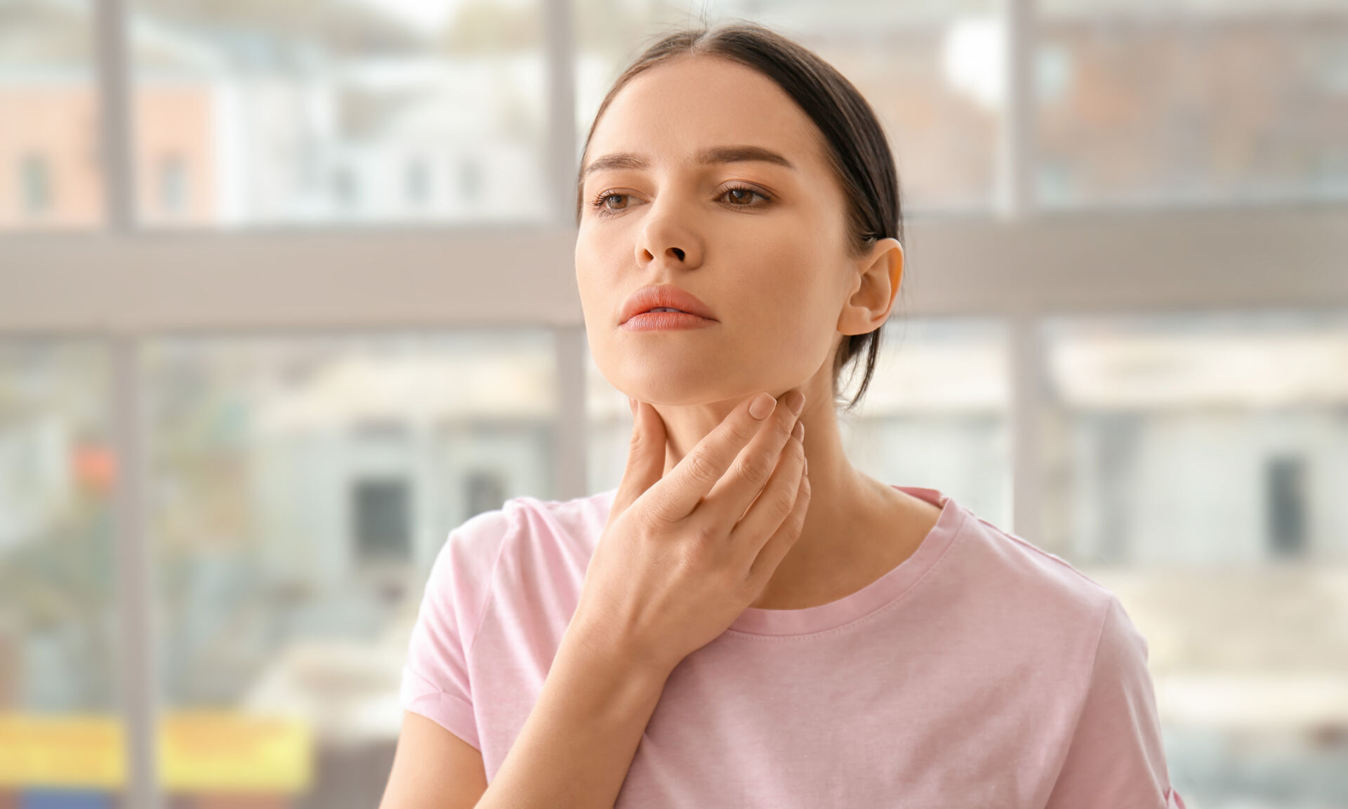 Young woman with thyroid gland problem at home