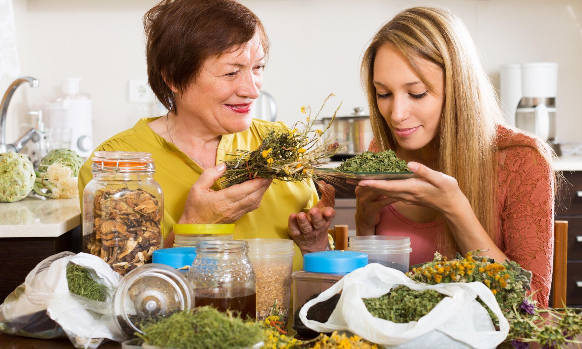 Happy womans with medicinal herbs brewing herbal tea