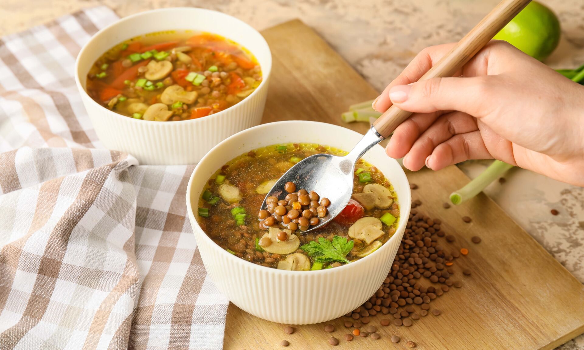 Woman eating tasty lentil soup from bowl