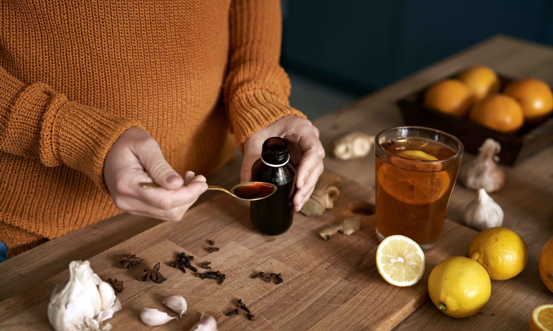 Sick woman preparing syrup for flu at autumn season