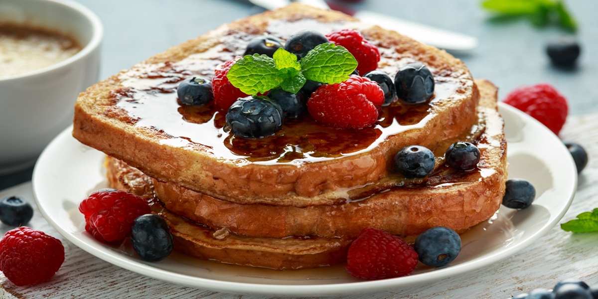 French cinnamon toast with blueberries, raspberries, maple syrup and coffee. morning breakfast