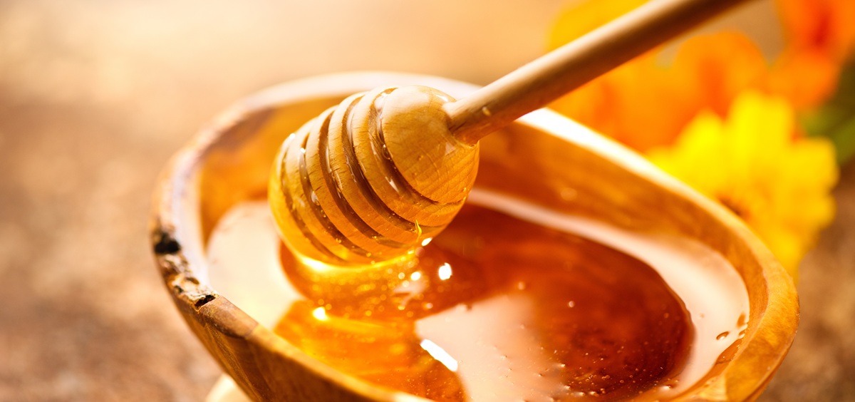 Honey. Healthy organic thick honey dripping from the honey dippe